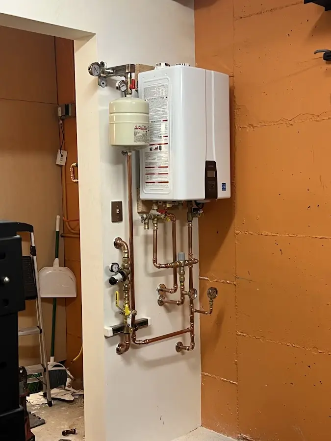 Plumbing technician inspecting water heater connections in Blooming Grove